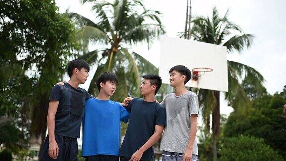一群十几岁的中国男孩在篮球场上在比赛结束后一起看着镜头