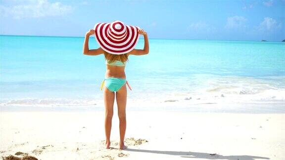 可爱的小女孩戴着帽子在海滩在加勒比度假