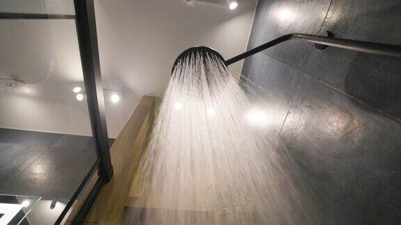水从雨淋浴头在深蓝色现代豪华浴室