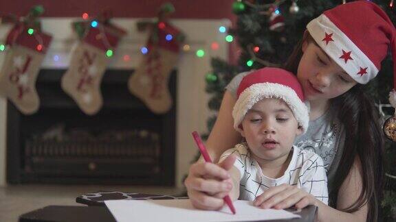 小男孩在姐姐的帮助下给圣诞老人写信
