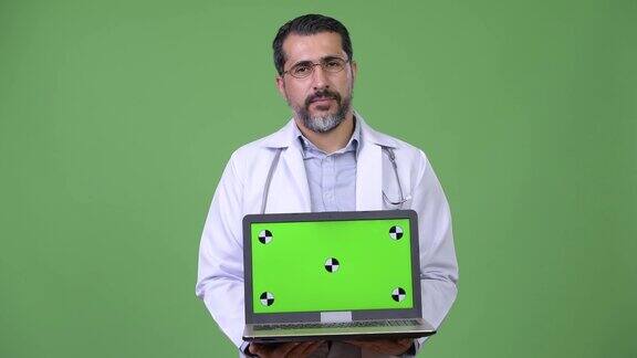 英俊的波斯胡子男子医生展示笔记本电脑