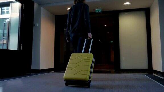 一个女人拿着旅行袋走向她的酒店房间