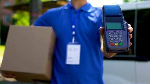 快递员拿着盒子和支付终端信用卡设备客户服务