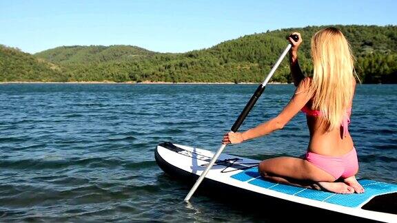 金发女人paddleboarding