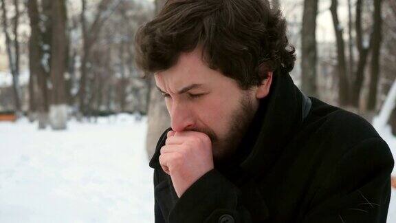 一个英俊的男人在雪地里咳嗽