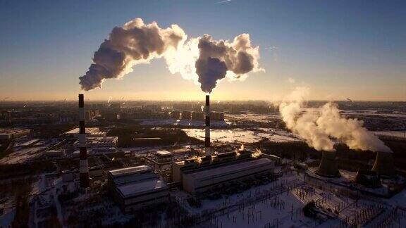 冒烟的烟囱发电厂的背景在冬天日落鸟瞰图
