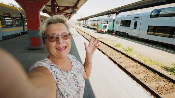 一位坐火车旅行的老年妇女正在自拍