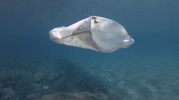 塑料污染白色塑料袋在bubuwater慢镜头丢弃的塑料袋在阳光下的蓝色水面下慢慢漂浮欧洲地中海漂浮着白色塑料袋