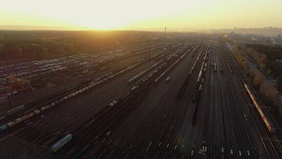 鸟瞰图日落时分的铁路分拣站在一个工业货运站的许多货车和铁路轨道火车沿着轨道行驶美丽的日落重工业景观