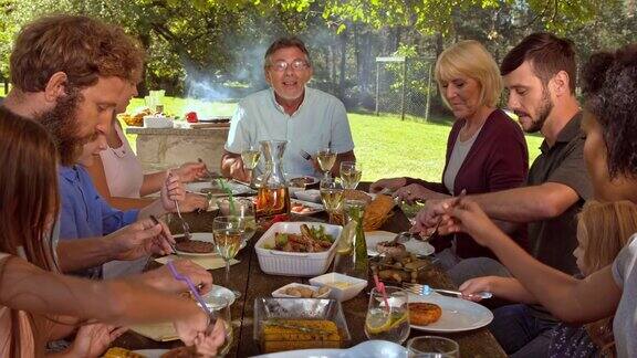 一个阳光明媚的日子一家人在野餐桌上吃饭