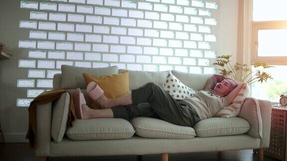 疲惫的亚洲中年妇女躺在家里的沙发上