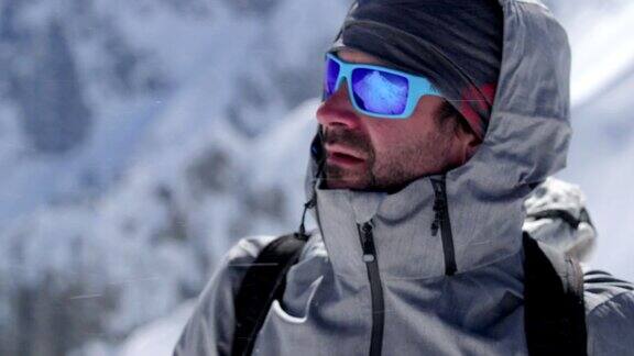 在阳光明媚的日子里登山者在雪山顶上的肖像登山滑雪活动滑雪者冬季在高山户外进行滑雪运动侧视图慢动作60p4k视频