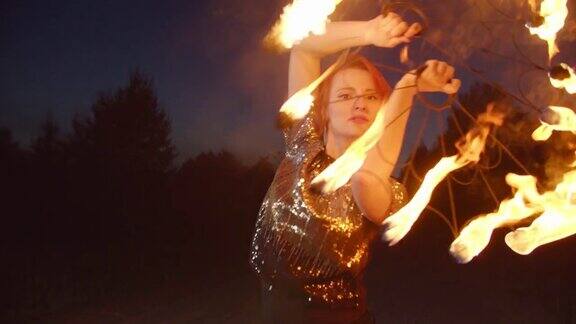 女人用燃烧着的扇子围着火