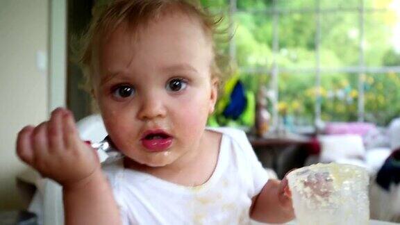 小婴儿浑身都是食物可爱的蹒跚学步的婴儿在吃晚餐时弄得一团糟
