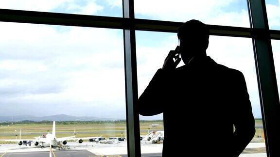 商人在机场用移动电话交谈