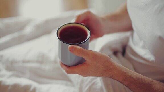 早上男人坐在床上喝茶
