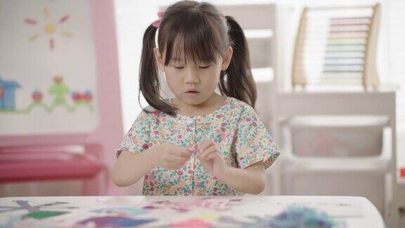小女孩亲手制作雪花工艺品供家庭学习