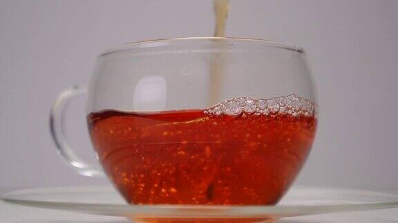 将红茶倒入一个透明的玻璃杯中