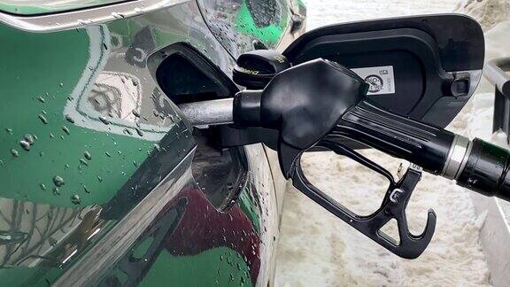 汽车油箱中的汽油喷嘴在加油站给汽车加柴油汽油燃油喷嘴插入汽车油箱燃料、加油站、汽油价格概念