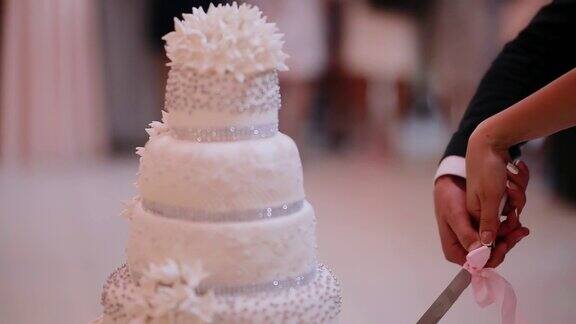 婚礼蛋糕宴会上的传统庆祝甜点新娘和新郎剪一块