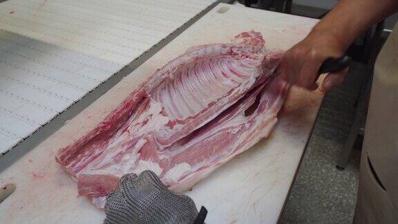 在肉类生产中分离肉类和排骨肉厂工人在切肉