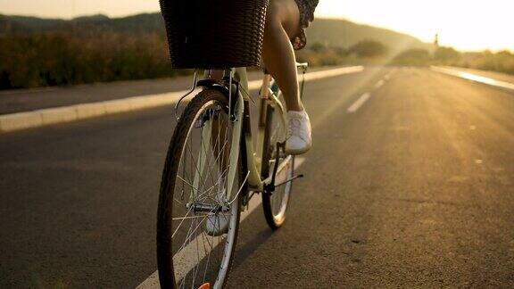 一个年轻女子在日落户外骑自行车的细节