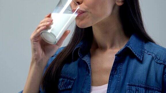 欢快的女人喝着一杯牛奶健康的饮料必不可少的营养成分