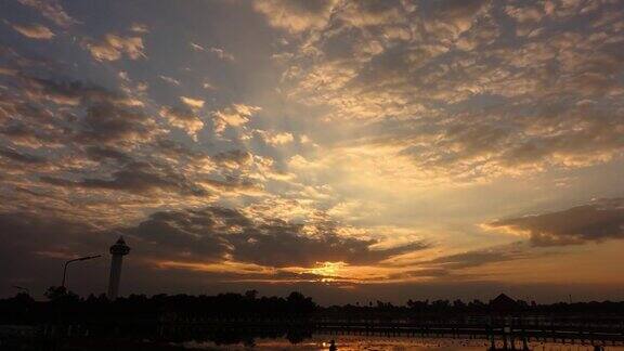 4K;戏剧性的时间流逝风暴云上的日落傍晚大橘色的晚霞笼罩天空泰国塞赛特湖上在夕阳的映衬下风暴云在天空中移动