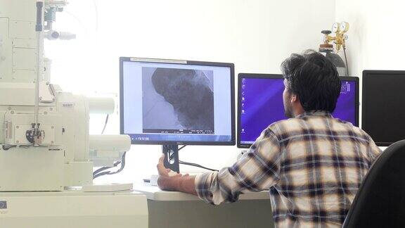 年轻研究员在电脑显示器上分析科学样本