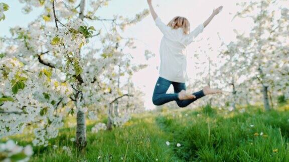慢动作女人在樱花中快乐地跳跃