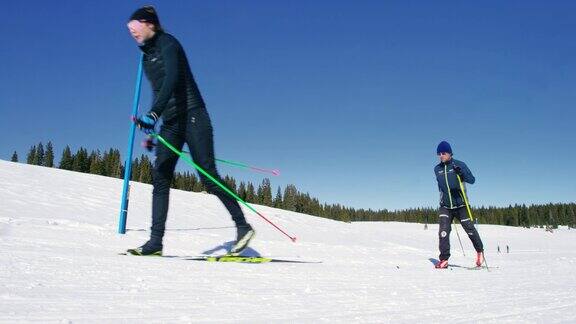 一组四个成年人越野滑雪在一条线在一个阳光明媚冬日在科罗拉多的慢动作镜头