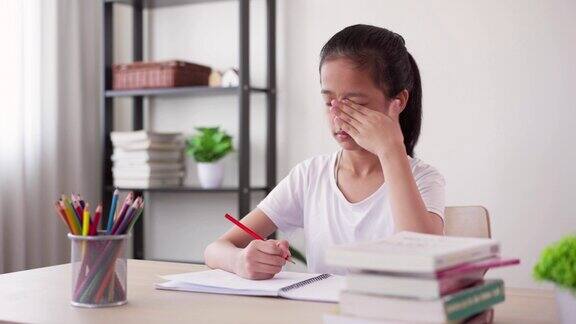 压力集中的女孩在家里学习和做作业感到头痛