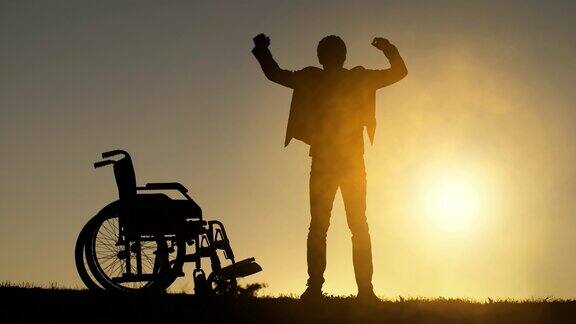 残疾人从轮椅上站起来并举起双手
