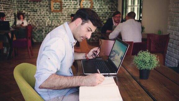 现代白人商人在自助餐厅用笔记本电脑工作