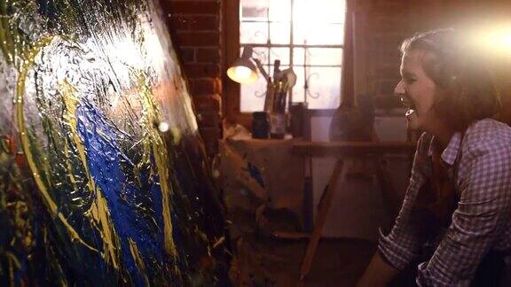 有才华的女艺术家在画布上用喷溅绘画技术作画