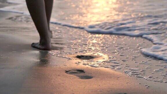 一个孤独的女人走在夕阳下的海滩上