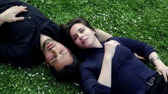 一对恋人躺在草地上温柔地聊天