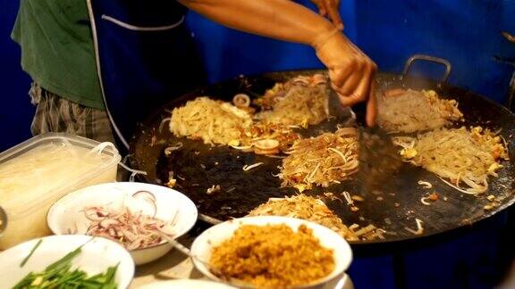 亚洲的街头食品海鲜、米粉搭配鸡蛋在大煎锅上煮缓慢的运动泰国