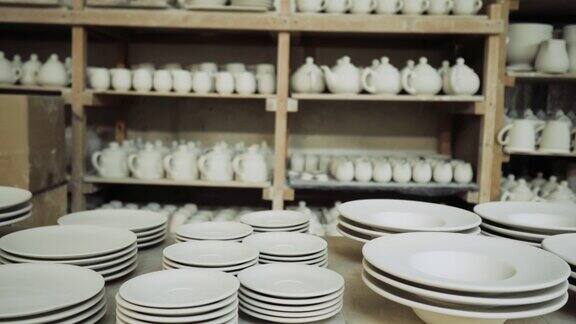 白色的陶瓷杯子和盘子在生产车间的货架上