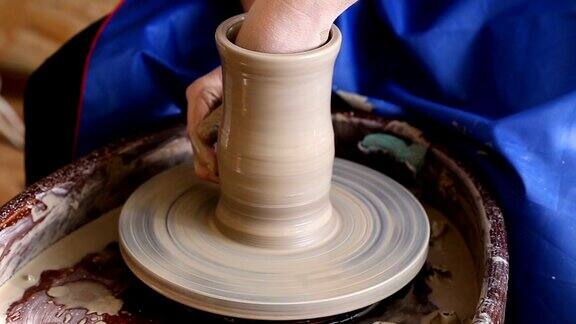 用粘土制造罐子或花瓶女人的手陶工的转盘