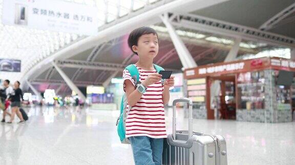 可爱的小男孩在火车站等着孩子旅行