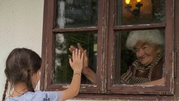 小女孩透过窗户探望祖母