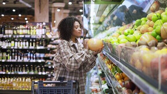 非裔美国妇女在超市挑选柚子