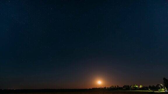 东欧白俄罗斯村庄上空月亮升起的时间间隔白俄罗斯乡村的房子在夏天的星夜
