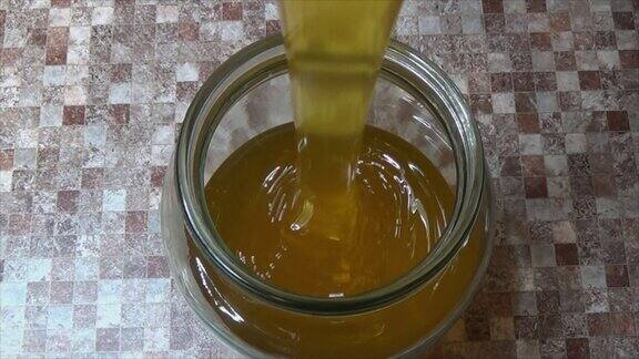 把蜂蜜倒进罐子的过程输注黄色、甜味、粘稠物