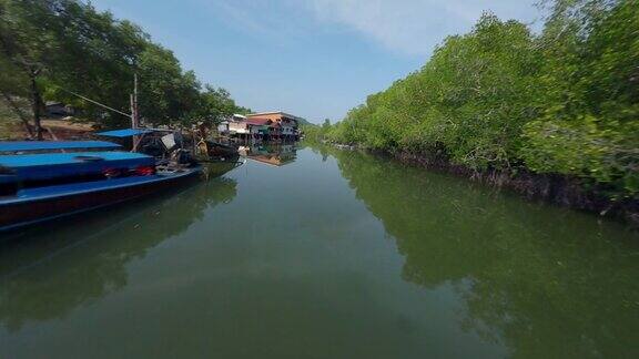 飞越亚洲村堤岸船水河当地农村房屋绿色森林鸟瞰图