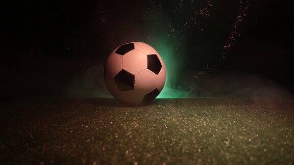 滑块传统的足球在足球场上近距离观看足球(足球)在绿色草地上与黑暗色调的雾背景有选择性的重点