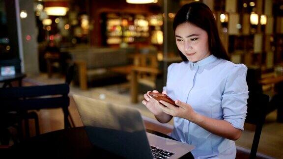 一个女人在咖啡馆用智能手机
