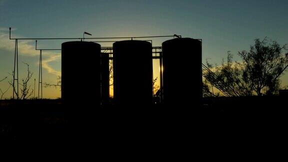 夕阳照耀着大油泵和储油罐