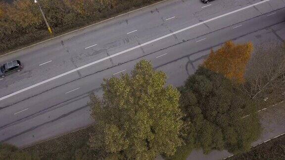 在秋天的背景下无人机可以看到高速公路上行驶的卡车和汽车